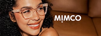 A woman with curly hair and clear chunky cat-eye glasses smiles while sitting on a brown sofa. The word 'MIMCO' appears in white text beside her.