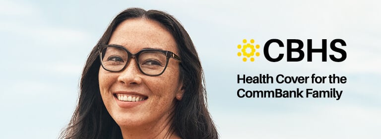 Woman wearing glasses smiling outdoors, with CBHS logo - Health Cover for the CommBank Family.