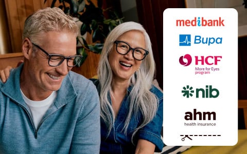 Smiling man and woman wearing glasses sit together indoors; logos of health insurance companies appear on the right.