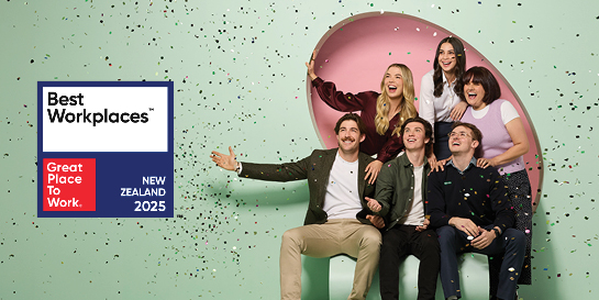 Six people celebrating with confetti next to a Best Workplaces Australia 2025 sign from Great Place to Work